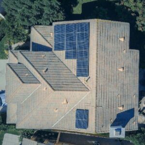 Aerial view of a commercial roof with solar panels and reflective coating for energy efficiency.