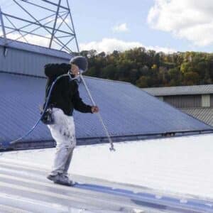 Troyer Commercial Roofing contractors applying an energy-efficient roof coating.