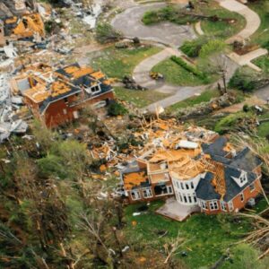 An aerial view of storm-damaged properties highlighting the importance of roof reinforcements.