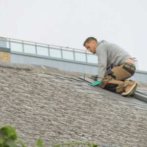a roofing contractor inspects and repairs the edge of a commercial roof, highlighting the key maintenance components such as checking for leaks, securing flashing, and preventing water infiltration.