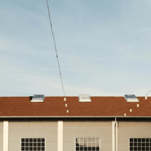a well-maintained commercial building with a clean tiled roof and skylights, emphasizing the key takeaways of regular roof maintenance, including longevity, cost savings, and insurance compliance.