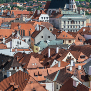 A dense cityscape with numerous terracotta-colored rooftops, showcasing different commercial and residential roofing styles and materials.