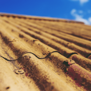 a close-up of a rusted metal roof with visible corrosion, illustrating the need for protective coatings and timely repairs to extend its lifespan.
