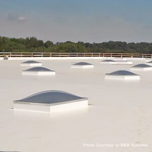 Domed skylights on a clean white commercial flat roof maintained by a licensed Florida roofing contractor