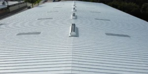 Aerial view of a properly installed white commercial metal roof with skylights and ridge vents in Florida