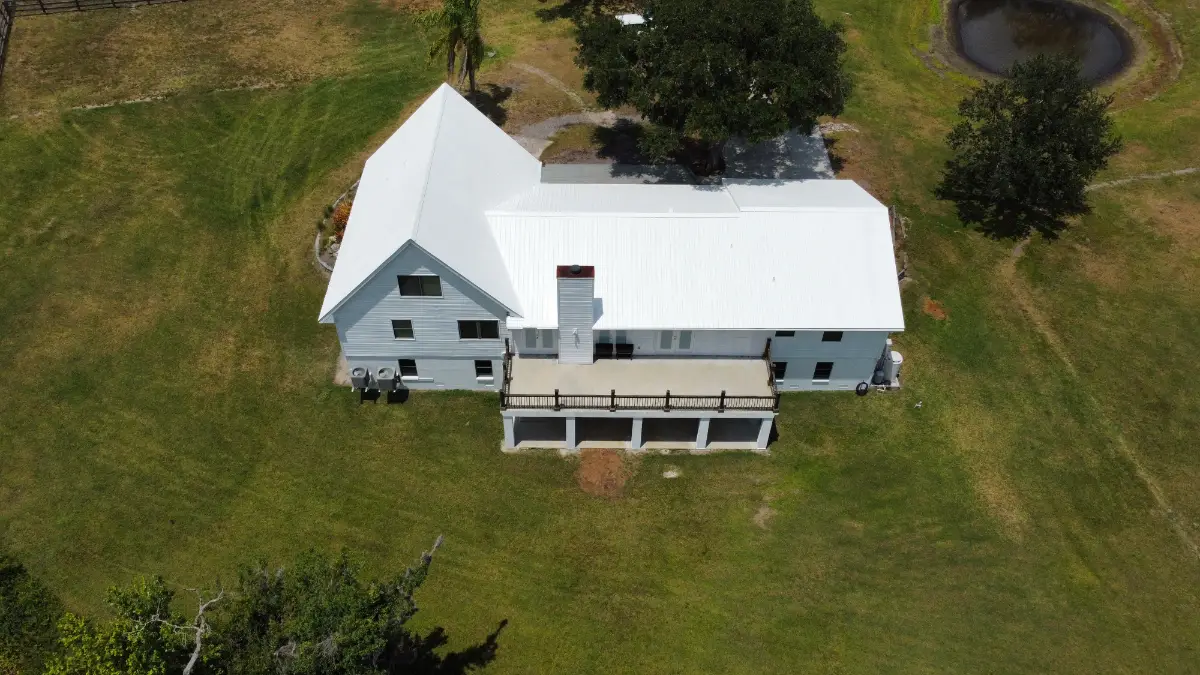 Aerial view of a Florida property with a newly coated white roof, showing the quality results property owners can expect from licensed and insured roofers.