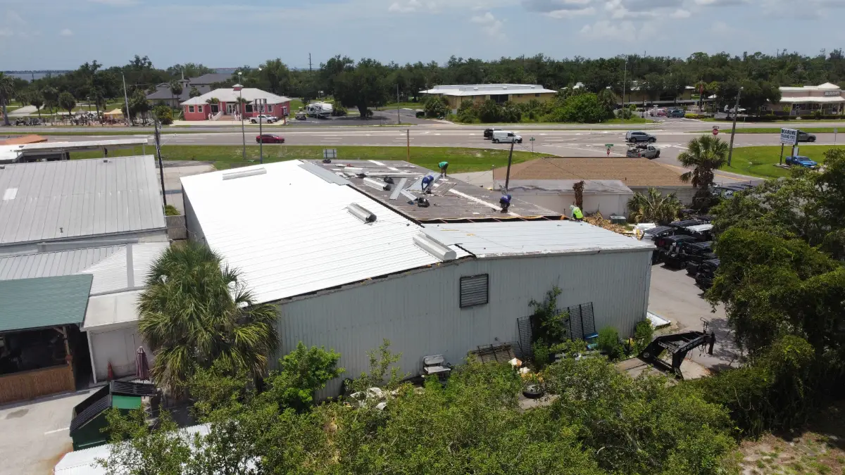 Aerial view of a commercial roofing crew working on a metal roof in Florida