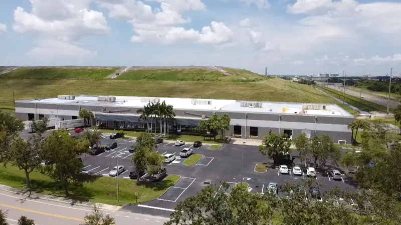 Freshly coated commercial roof with palm trees in the foreground.