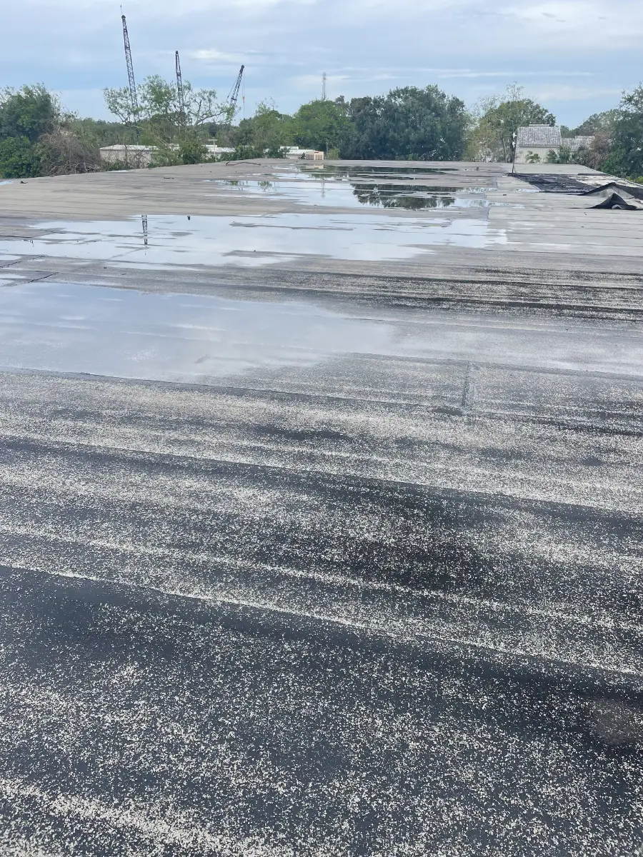 commercial-roof-ponding-water-before Commercial metal roof in Sarasota Florida showing ponding water and deterioration before restoration