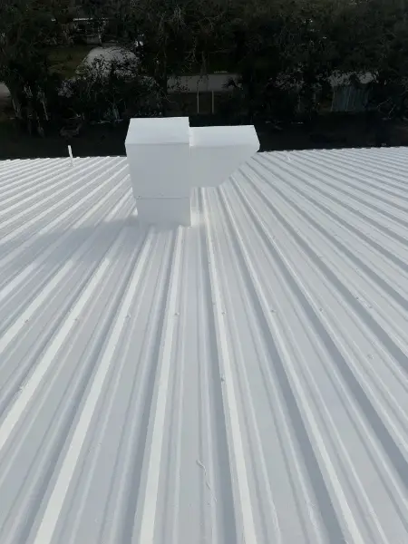 Finished commercial metal roof restoration with white reflective coating in Sarasota Florida