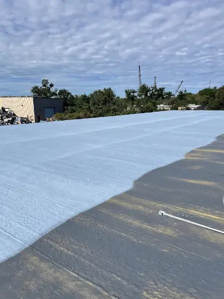 Application of reflective coating on commercial metal roof during restoration