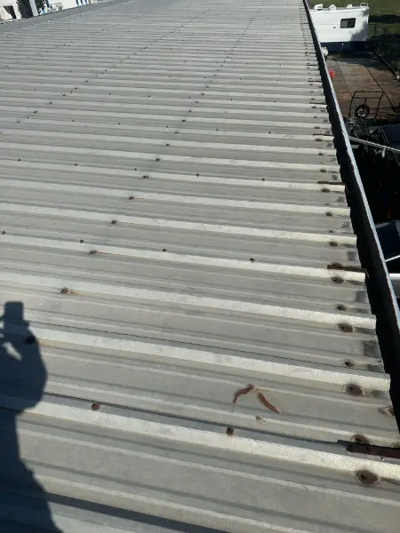 Close-up of metal roof with rusted screws and visible wear on Sarasota commercial property