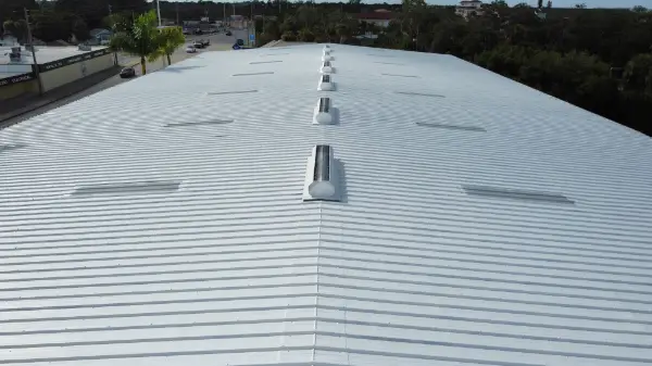 Troyer crew spray-applying a reflective coating on a commercial metal roof