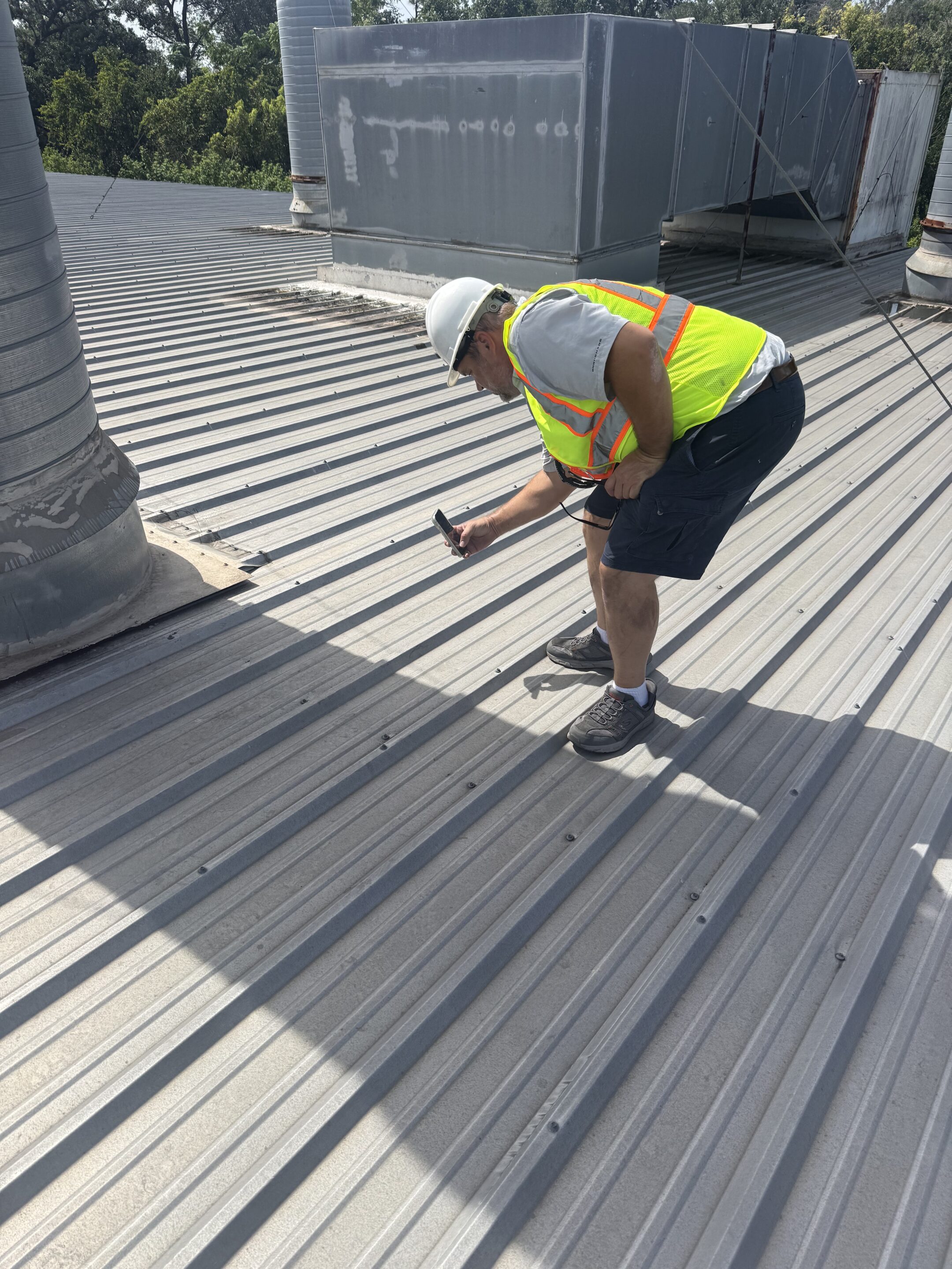 Lester Troyer inspecting a commercial metal roof in full safety gear