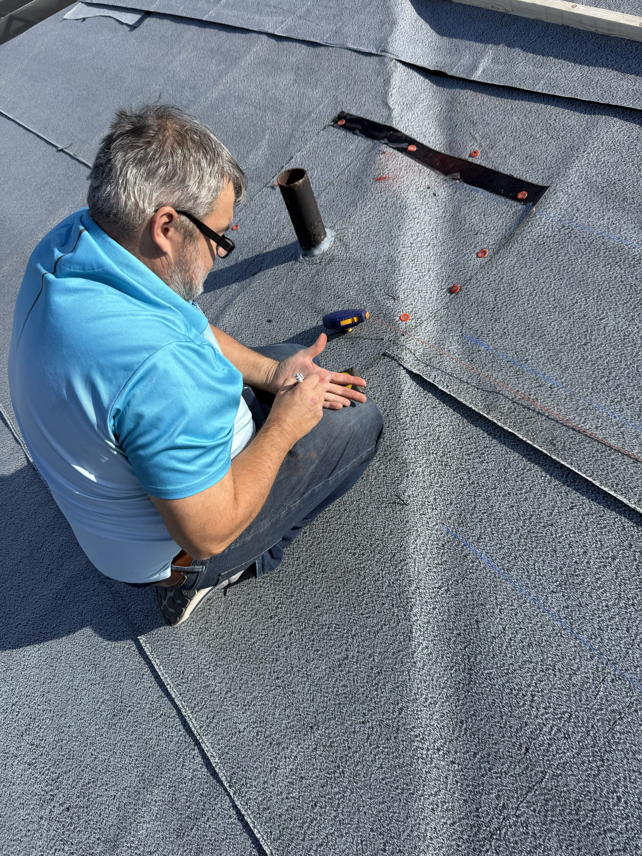 Lester Troyer marking out a repair section on a modified bitumen commercial roof