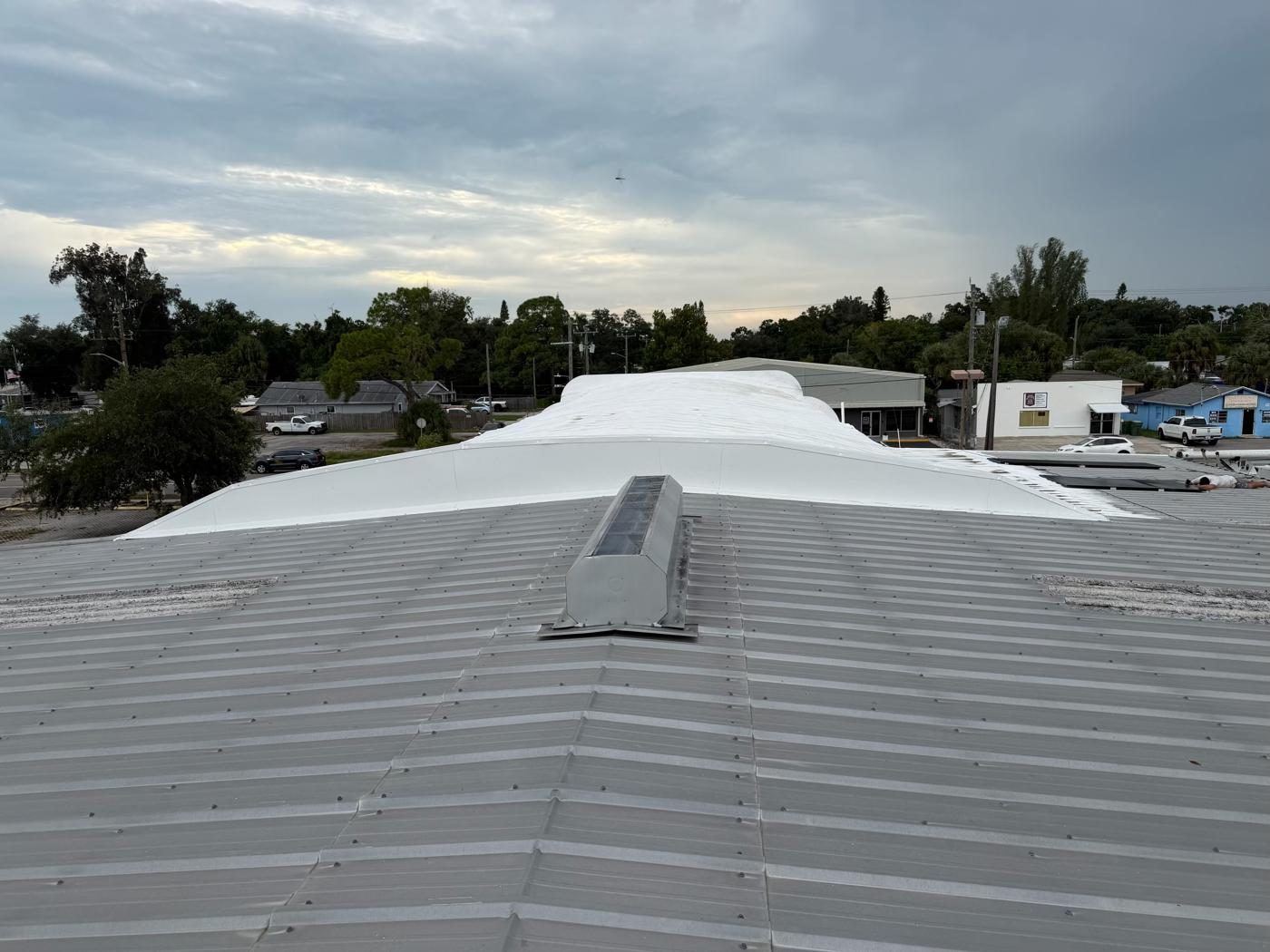 New custom metal flashing installed where a metal roof meets a spray foam roof on a commercial rental property in Bradenton