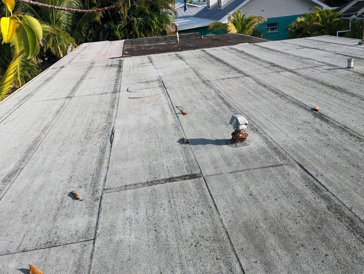 Storm-damaged gravel built-up commercial roof in Bradenton before spray foam restoration